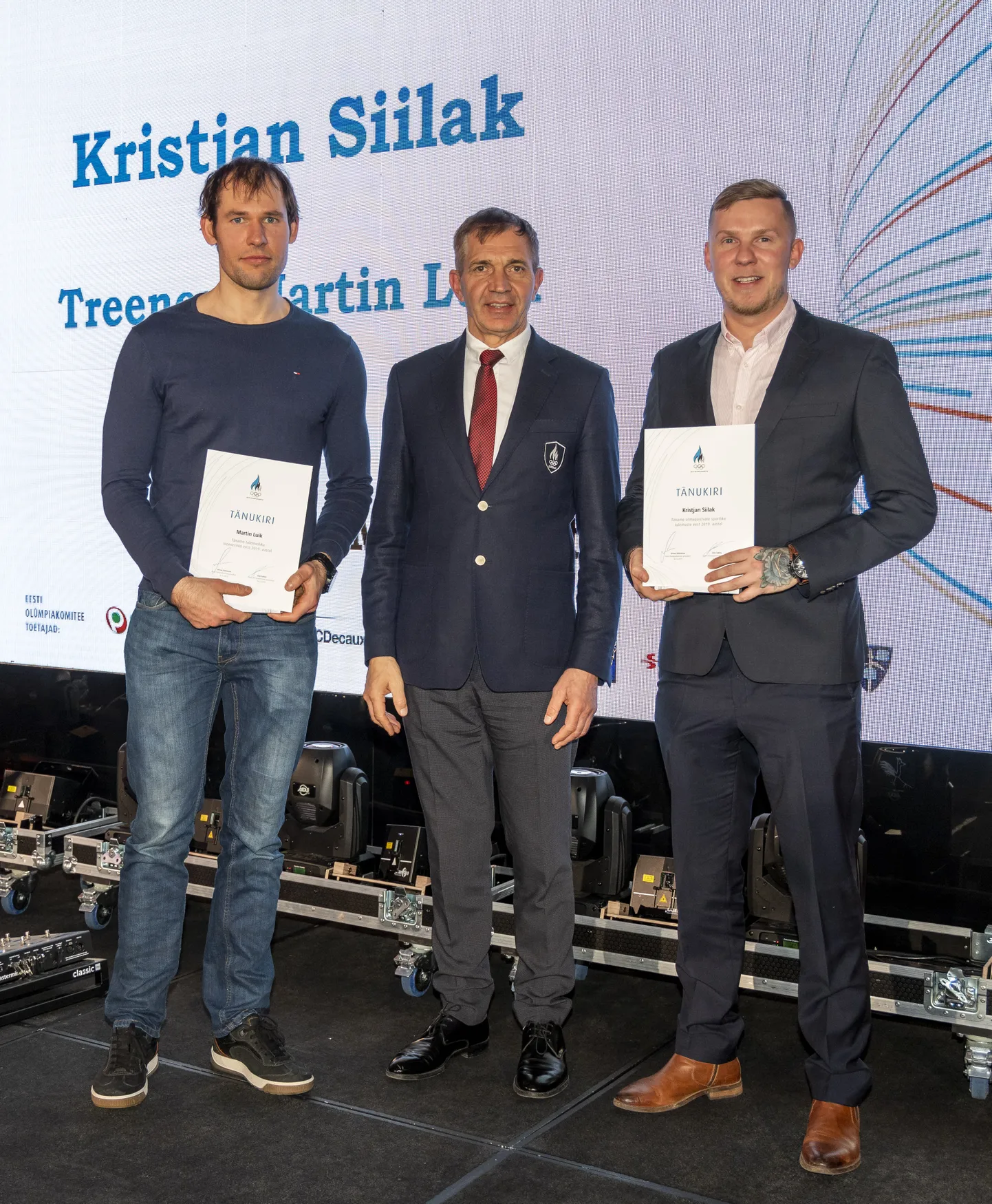 Valga motosportlane Kristjan Siilak (paremal) sai silmapaistvate sportlike tulemuste eest Eesti Olümpiakomiteelt tänukirja. Vasakul üldfüüsise personaaltreener Martin Luik ja keskel EOK president Urmas Sõõrumaa.