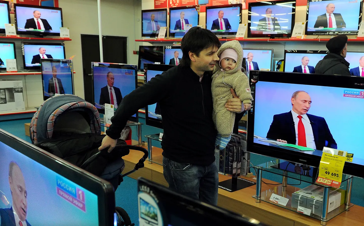 Beebit süles hoidev mees tehnikapoes Vladimir Putini otse-eetri ajal.