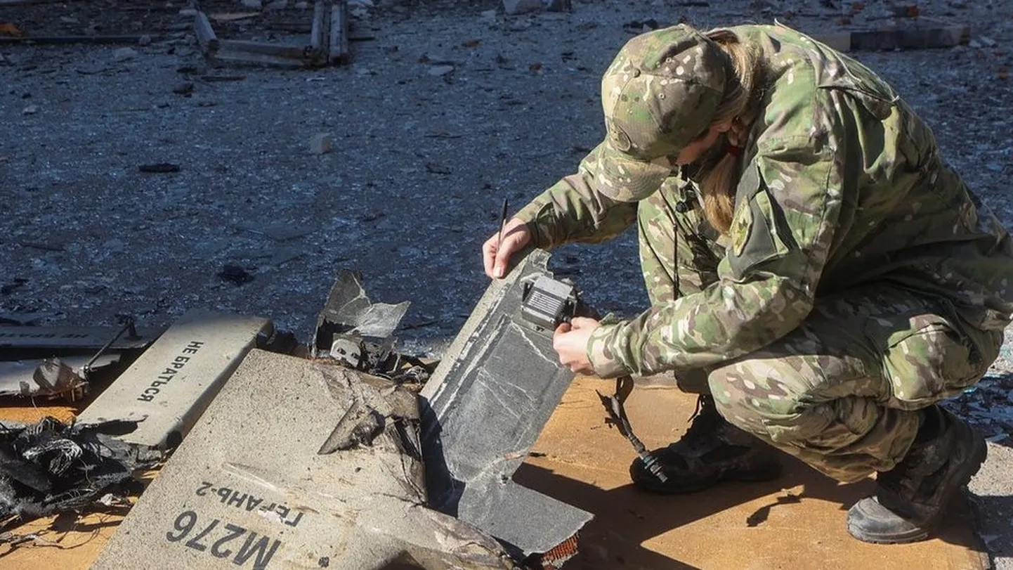 Украинский военный специалист исследует обломки иранского дрона "Шахед-136", атаковавшего инфраструктурный объект в Харькове 6 октября 2022 года