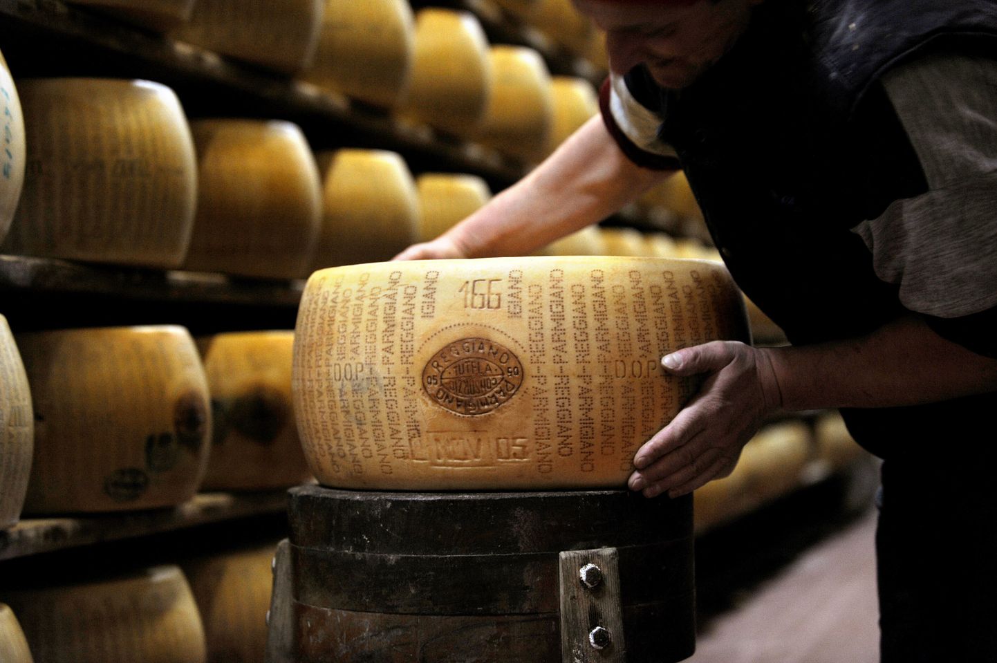 Töötaja Valestras Parmigiano Reggiano juustukeraga.