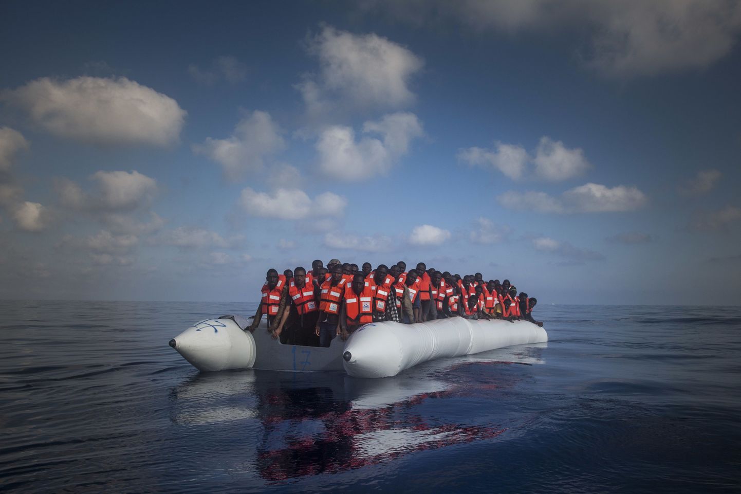 In this Thursday, July 28, 2016 photo, about 150 sub-Saharan refugees and migrants wait aboard an overcrowded rubber boat to be assisted by an NGO during a rescue operation on the Mediterranean Sea, about 23 kilometers (14 miles) north of Sabratha, Lybia. (AP Photo/Santi Palacios)