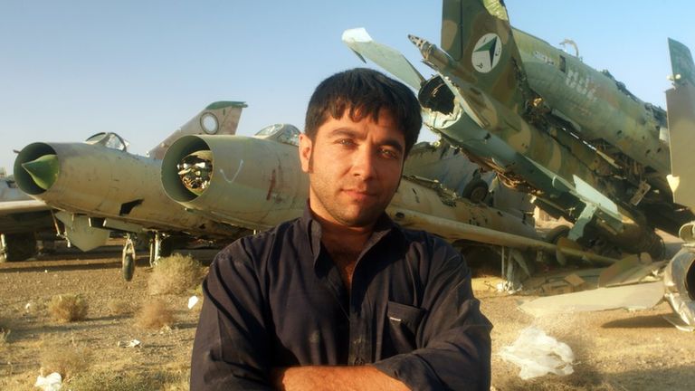 Мужчина позирует фотографу на фоне старых МиГ-21 с эмблемами ВВС правительства талибов