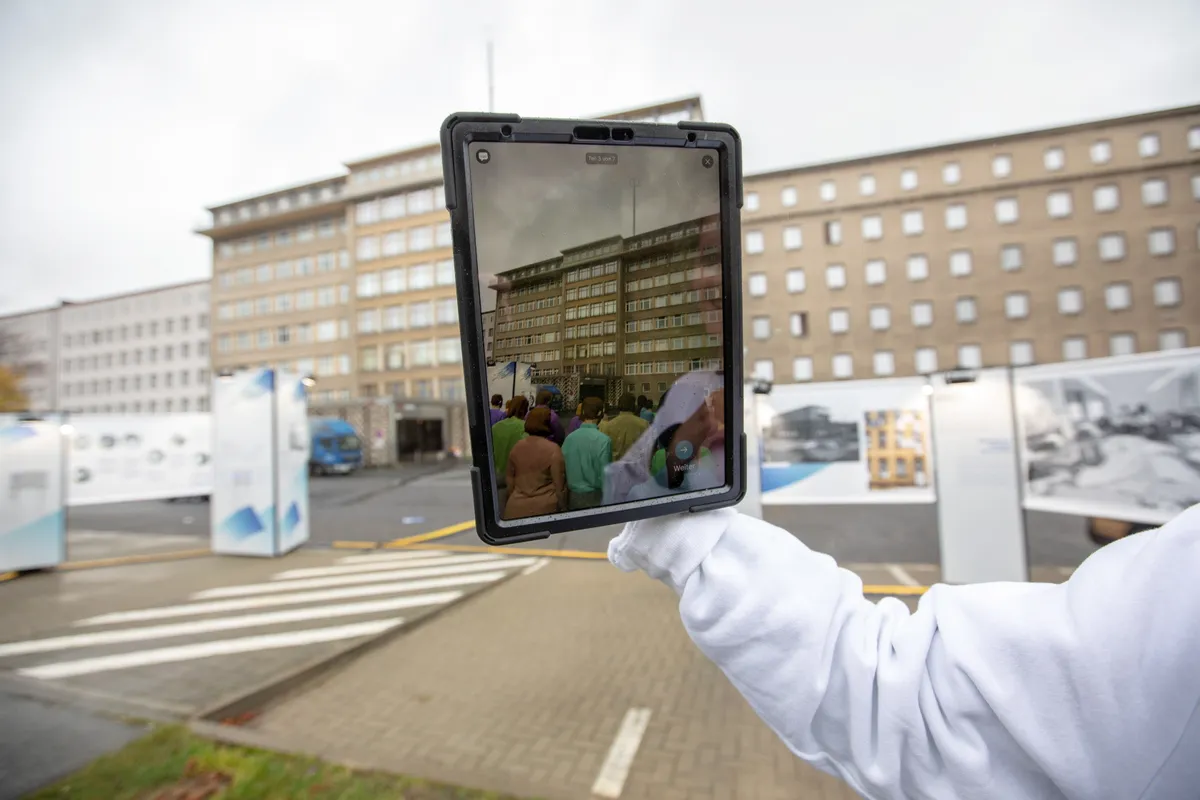 Giid hoidmas tahvelarvutit, kui ta tutvustab liitreaalsuse multimeedia installatsiooni Stasi muuseumi juures Beliinis.
