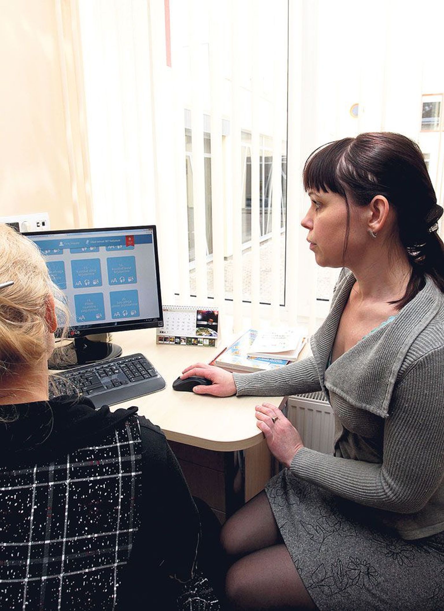 Logopeed Lea Kübar tutvustab patsiendile arvutis uut kõneravikeskkonda.