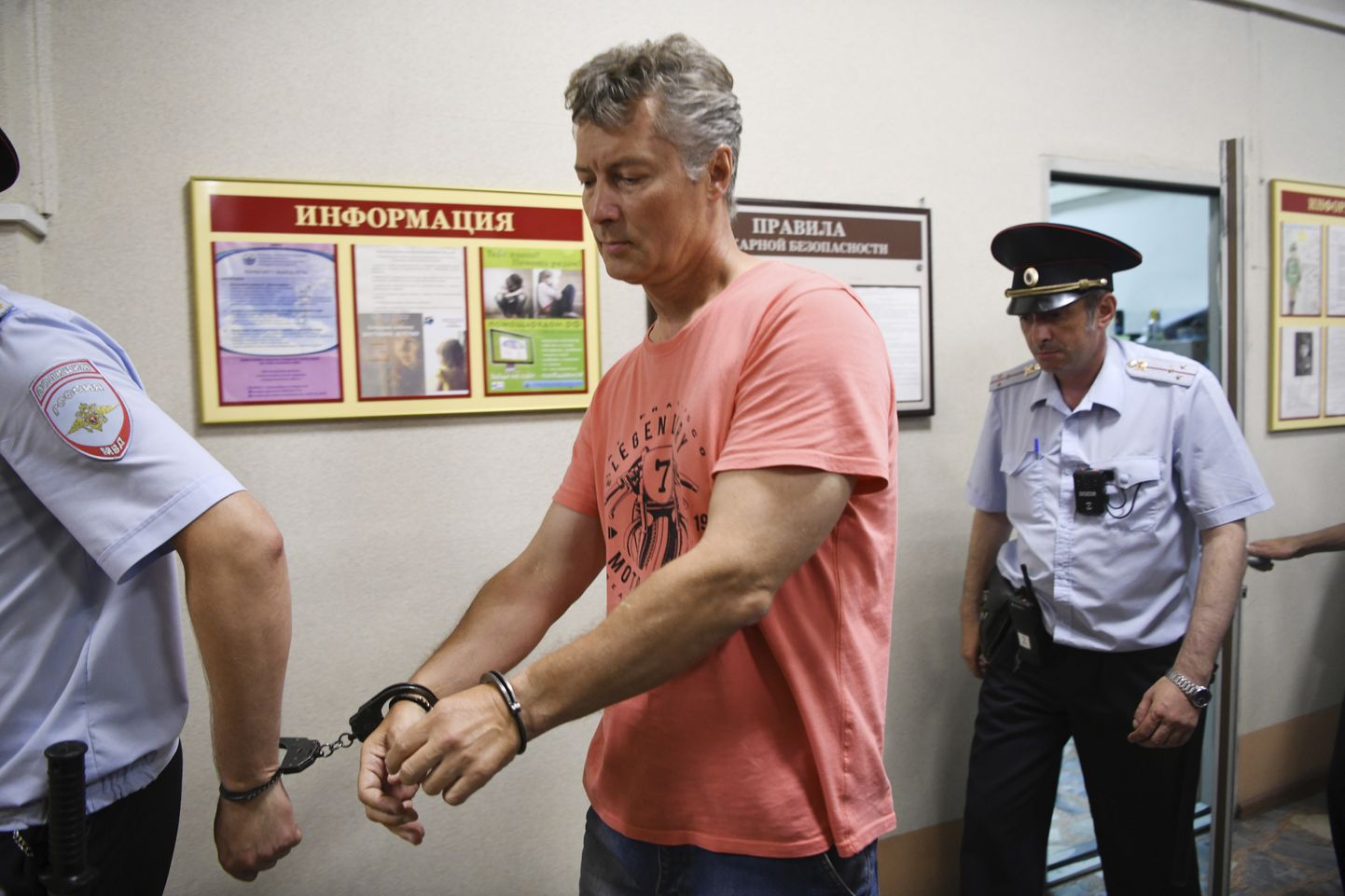 Полиция ведет Евгения Ройзмана в зал суда в Екатеринбурге, Россия, четверг, 25 августа 2022 года.
