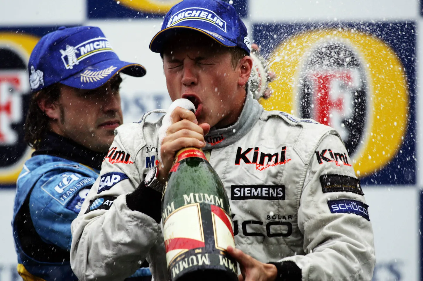 Kimi Räikkönen 2005. aastal, kui võitis McLareniga Belgia GP. Taustal tol aastal maailmameistriks tulnud Fernando Alonso, kes sõidab siiani F1s.