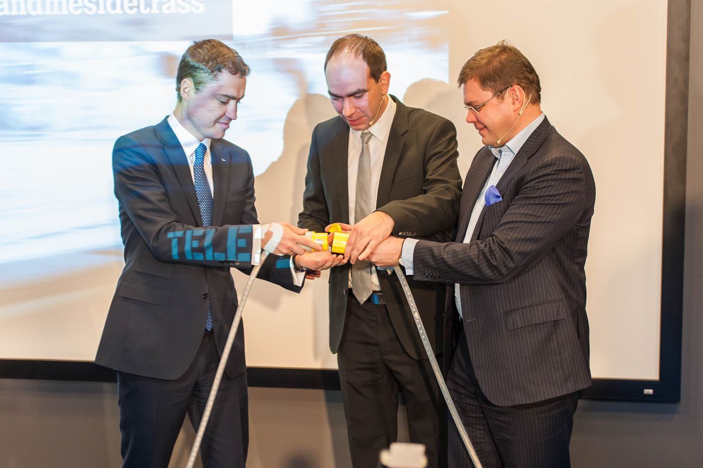 Sümboolselt aitab Tele2 juhtidel Argo Virkebaul (keskel) ja Niklas Sonkinil (paremal) Tallinn-Frankfurt sidekaablit ühendada peaminister Taavi Rõivas.