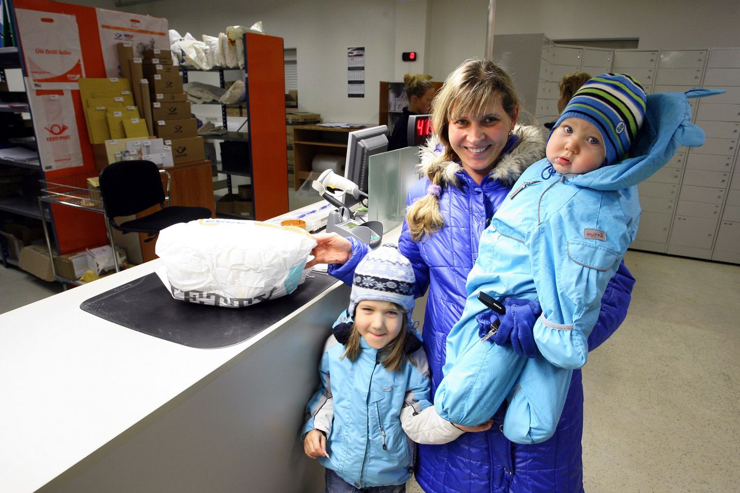 Kadrioru elanik Piret Liim koos tütre Birgiti (5) ja poja Eldariga (10kuud) Põhja-Tallinna kandekeskuses postipakki kätte saamas.