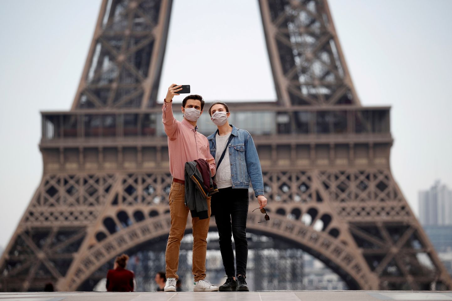 Korduvkasutatavas kangast näomaskis inimesed tegemas endast pilti Trocadero väljakul Eiffeli torni juures Pariisis.