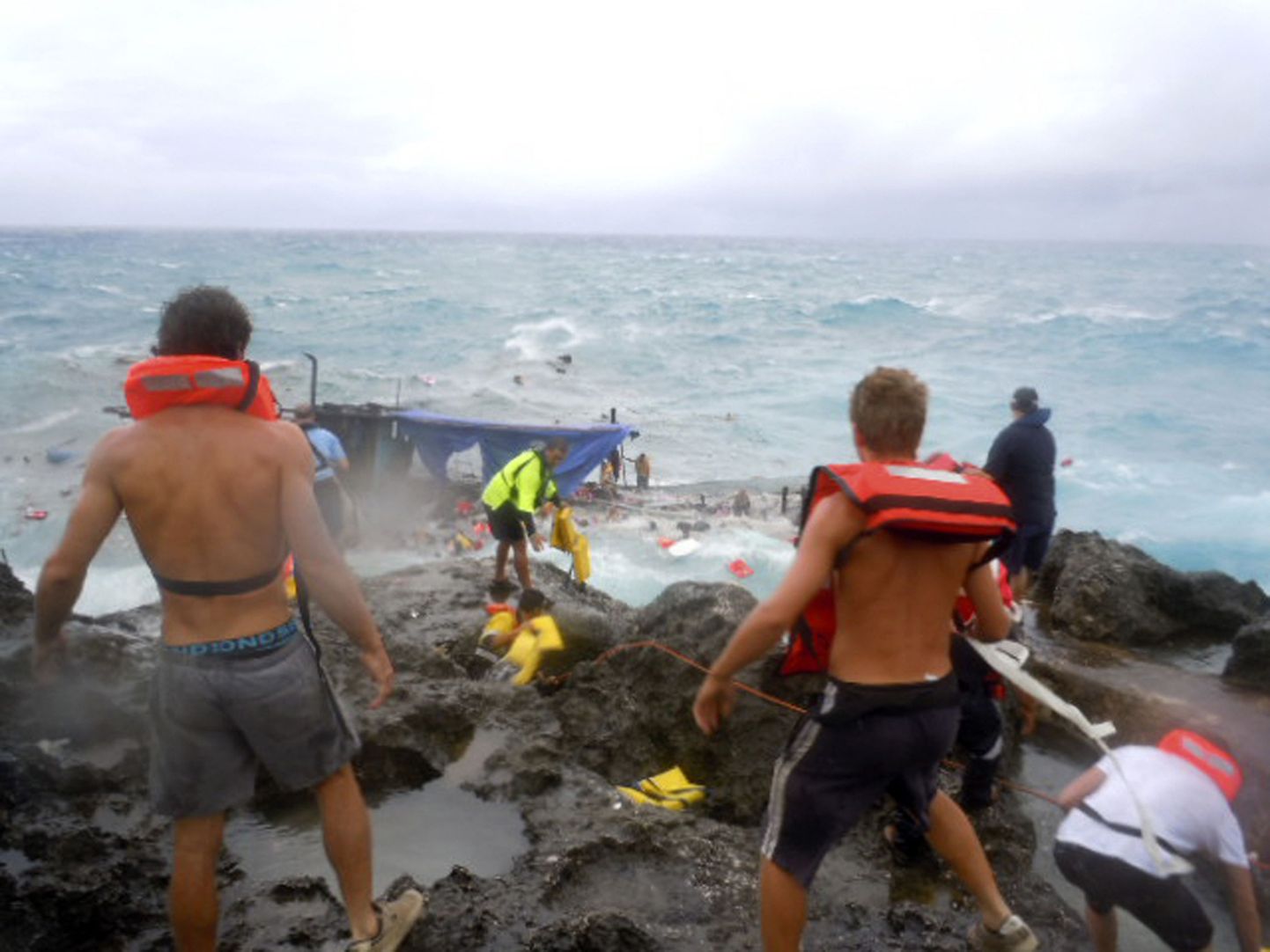 Kohalikud üritavad Jõulusaare rannikul paadiõnnetuse ohvreid päästa.