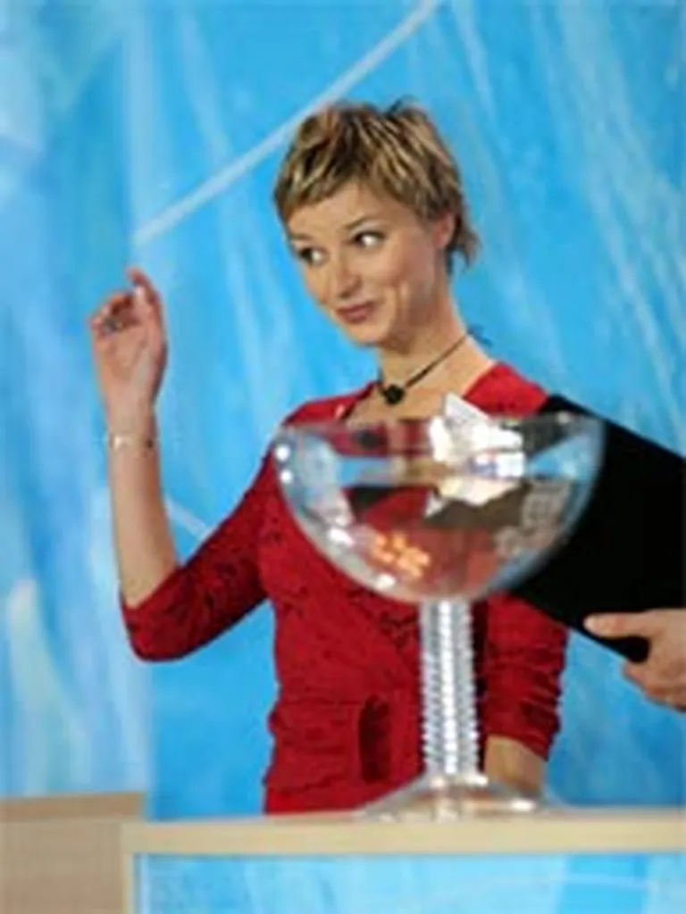 Dziedātāja Marija Naumova koķetē ar klātesošajiem pasaules čempionāta izlozes laikā.