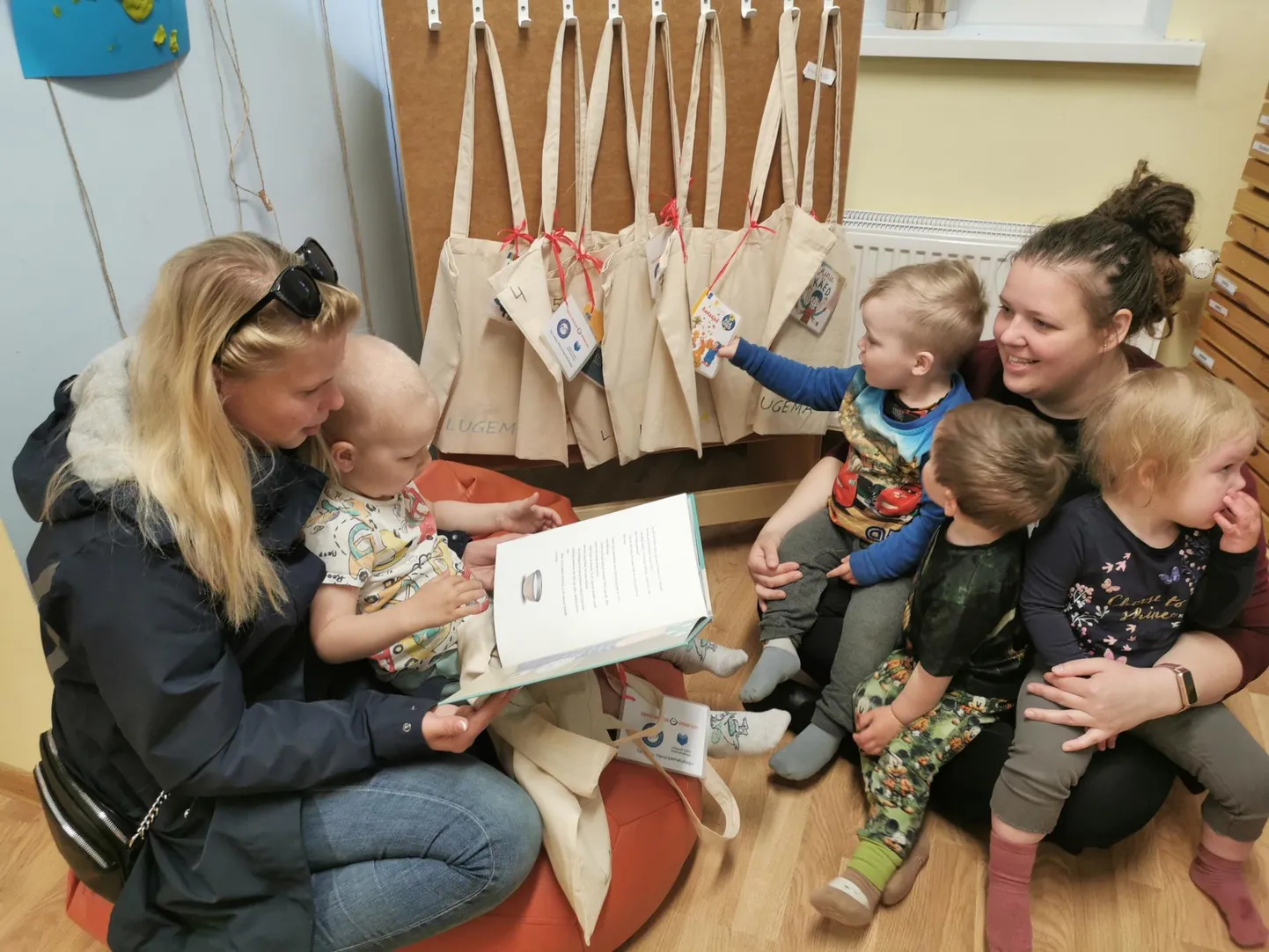 Strastini Mary-Liis üten oma poja Joosepige ja Muumi rühmä õpeteje Lumi Helena lasteaialastege tunneve raamatukotte üle rõõmu.