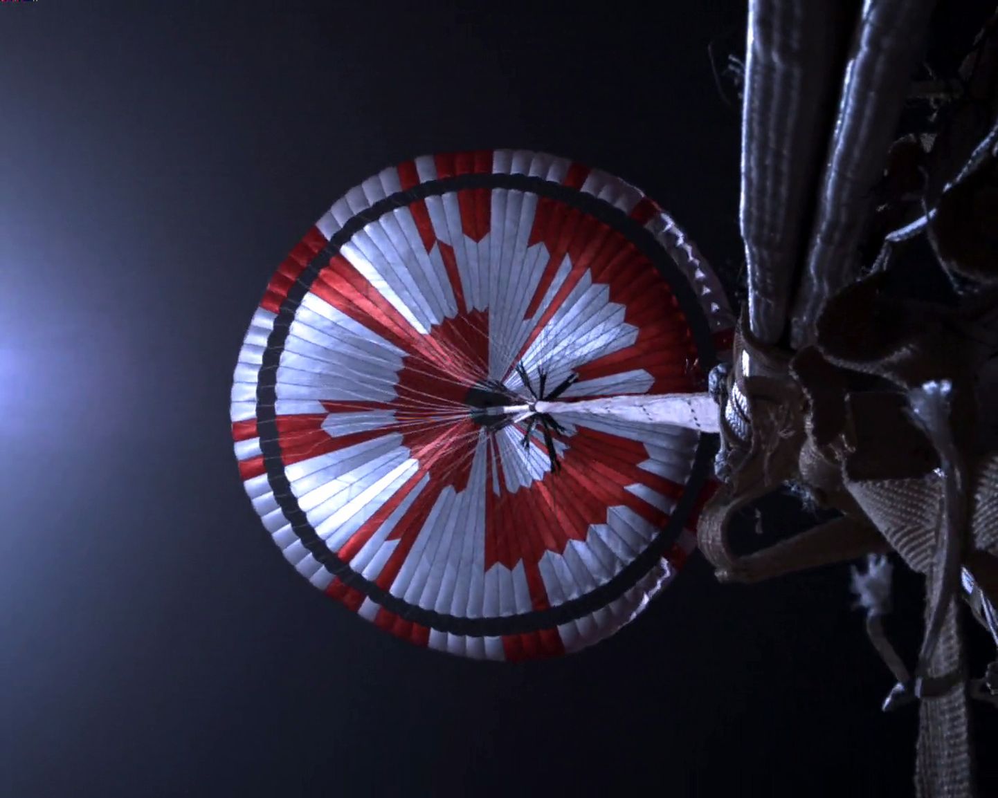 Videokaader, millel on näha kulgur  Perseverance'i maandumist Marsile punavalge langevarju abil