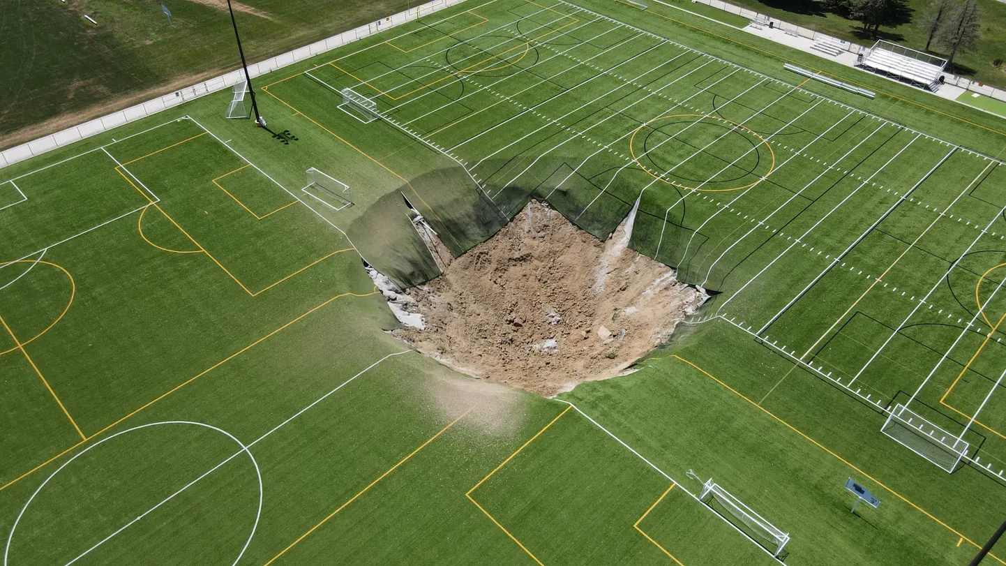 Провал, образовавшийся на футбольном поле в США, сняли с дрона.