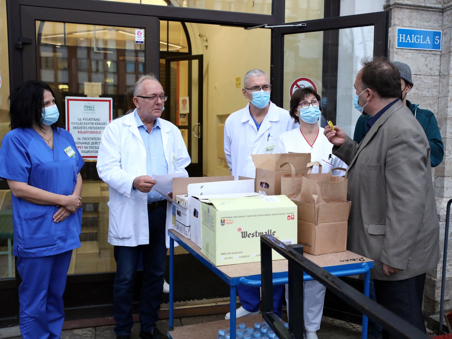 Кармо Тюэр (справа) передает приобретенные на пожертвования товары сотрудникам Нарвской больницы во главе с заведующим больницей Аго Кыргвеэ (второй слева).