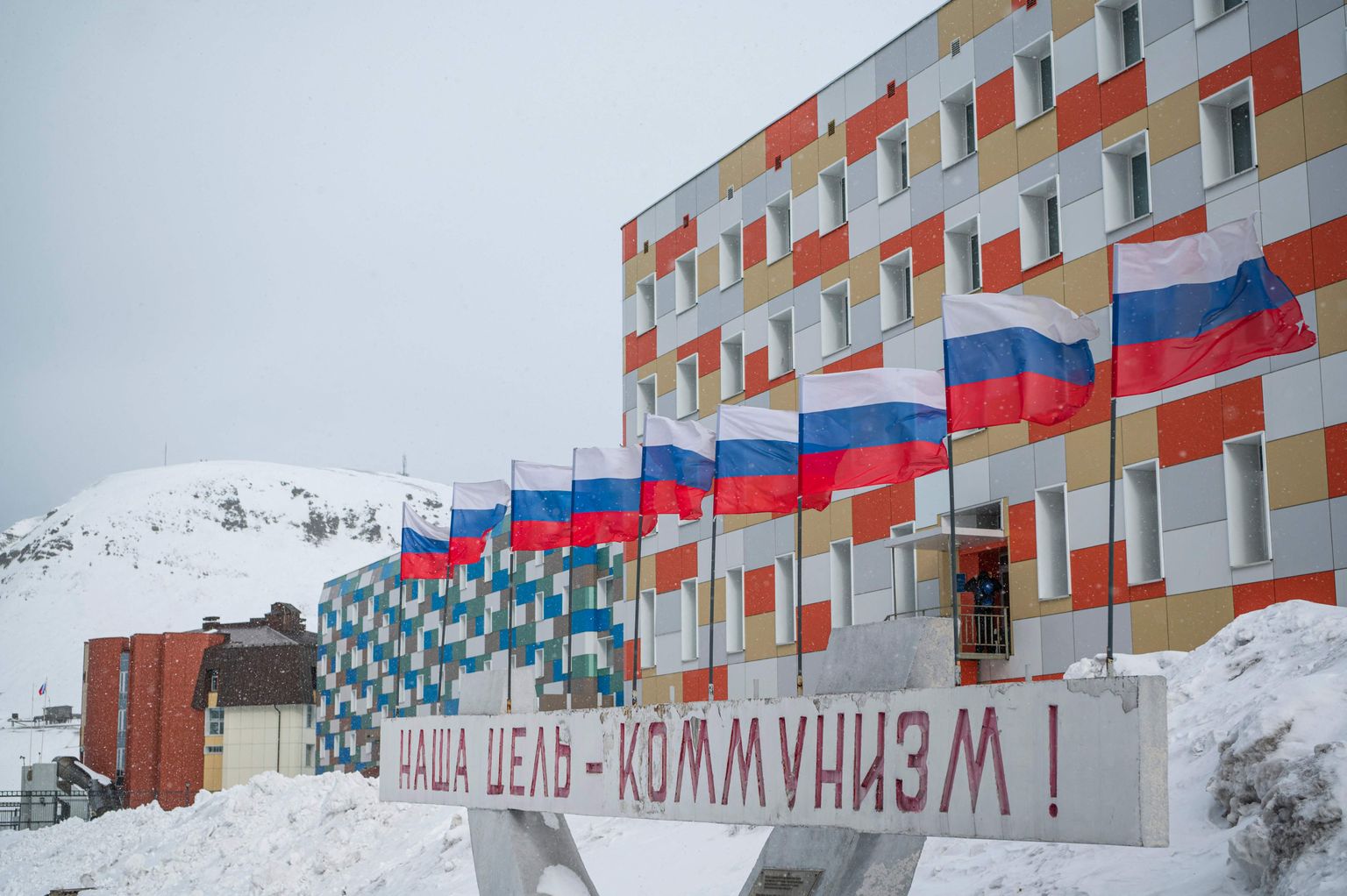 "Meie eesmärk on kommunism" kuulutab kiri Vene lippude all korrusmaja ees Svalbardil asuvas kaevuritelinnas Barentsburgis.