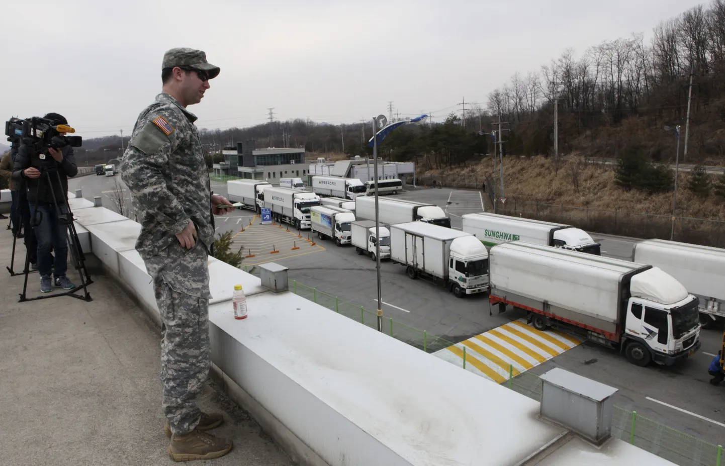 Lõuna-Korea veokid naasevad Kaesongi tööstuspargist. Autode liikumist jälgib USA sõdur.