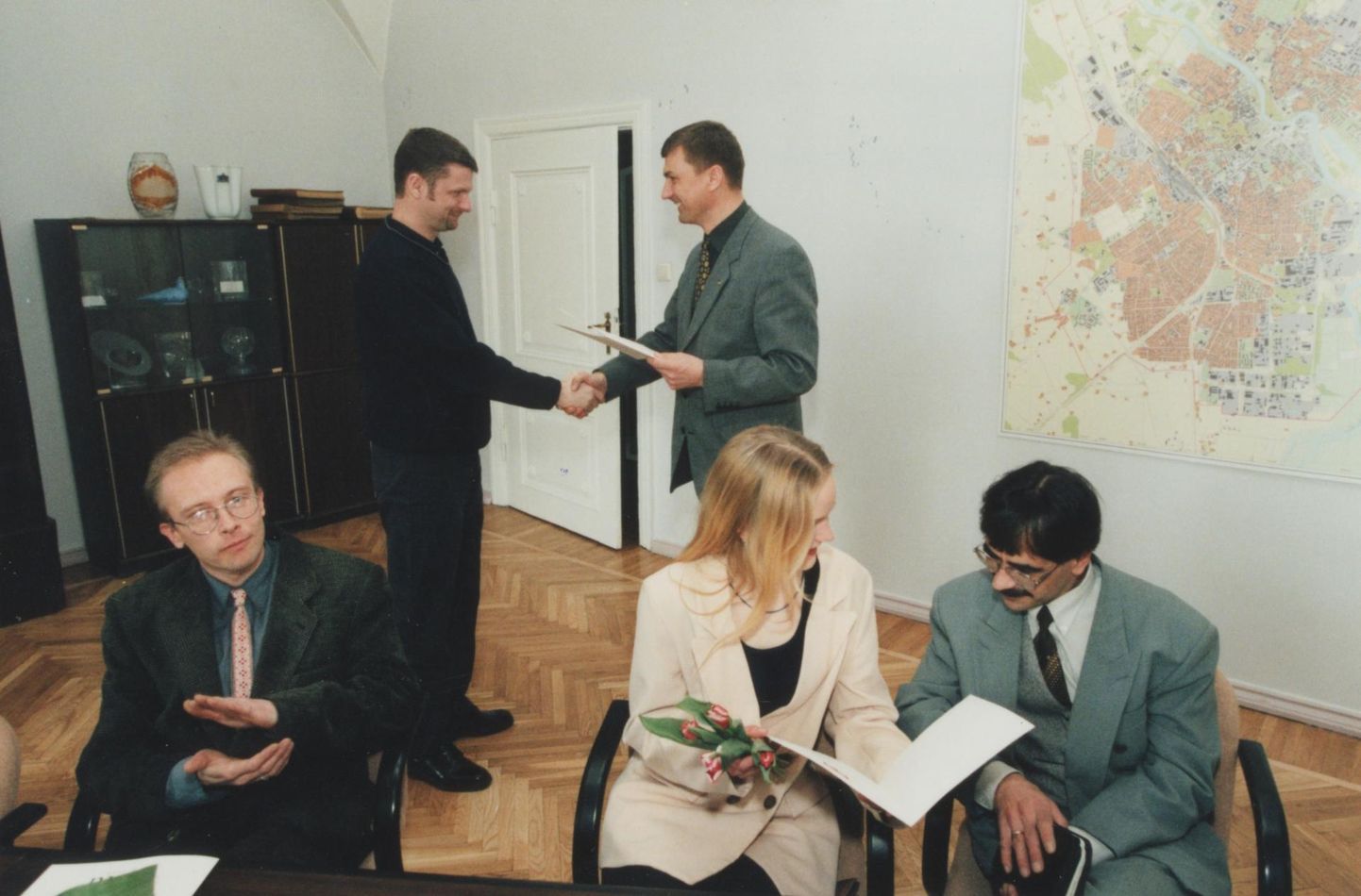 Linnapea Andrus Ansip (taga paremal) andis 23. märtsil 1999 raekojas Aivar Viidikule kätte Tartu tunnuslause konkursi võidupreemia. Laua taga istuvad tõenäoliselt isikud, kes tunnistati oma lausega teise ja kolmanda koha vääriliseks.