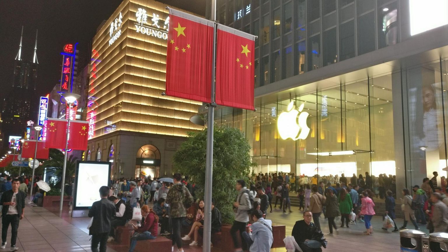 Ida tõusuteel: Shanghai kaubatänaval ilutsevad kõrvuti kommunistide punaplagu ja tehnoloogiaimpeeriumi Apple’i neoonlogo. 