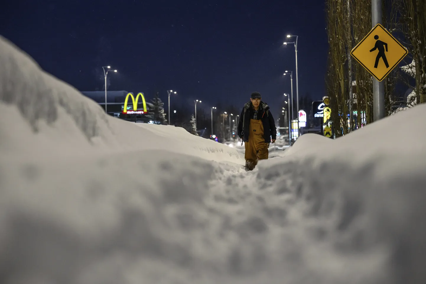 Jalakäija pärast lumetormi tänaval jalutamas.