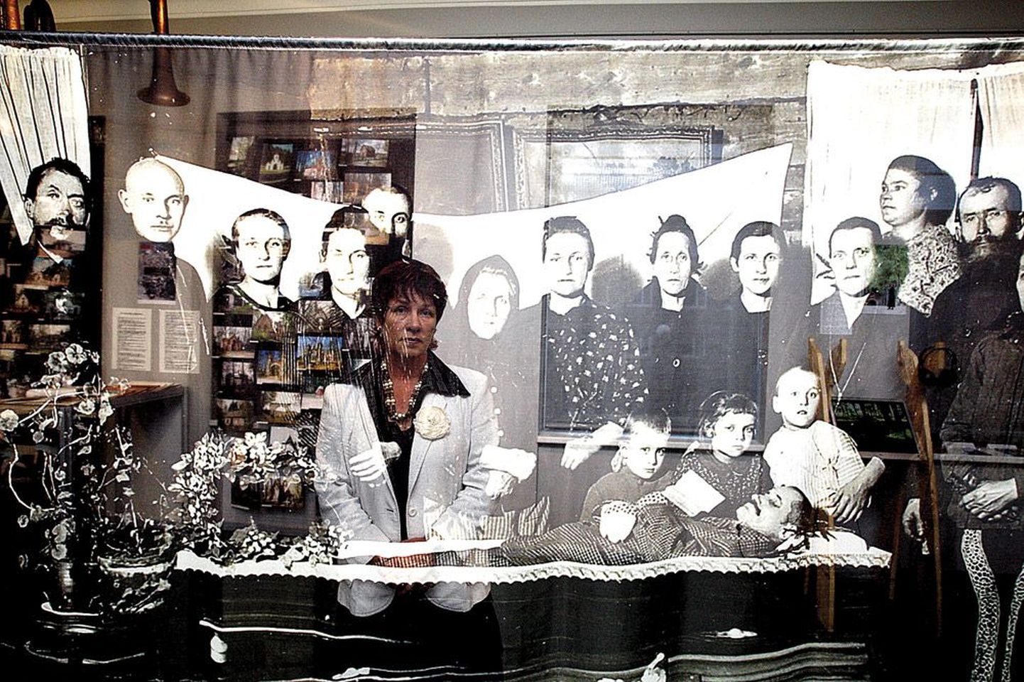 Näituse «Eesti matus» kuraator Maire Sala (vasakult kuues) tunnustas väljapaneku kujundajaid, kes on keset näitusesaali riputanud pooleldi läbipaistva suurenduse vanast matusepildist.