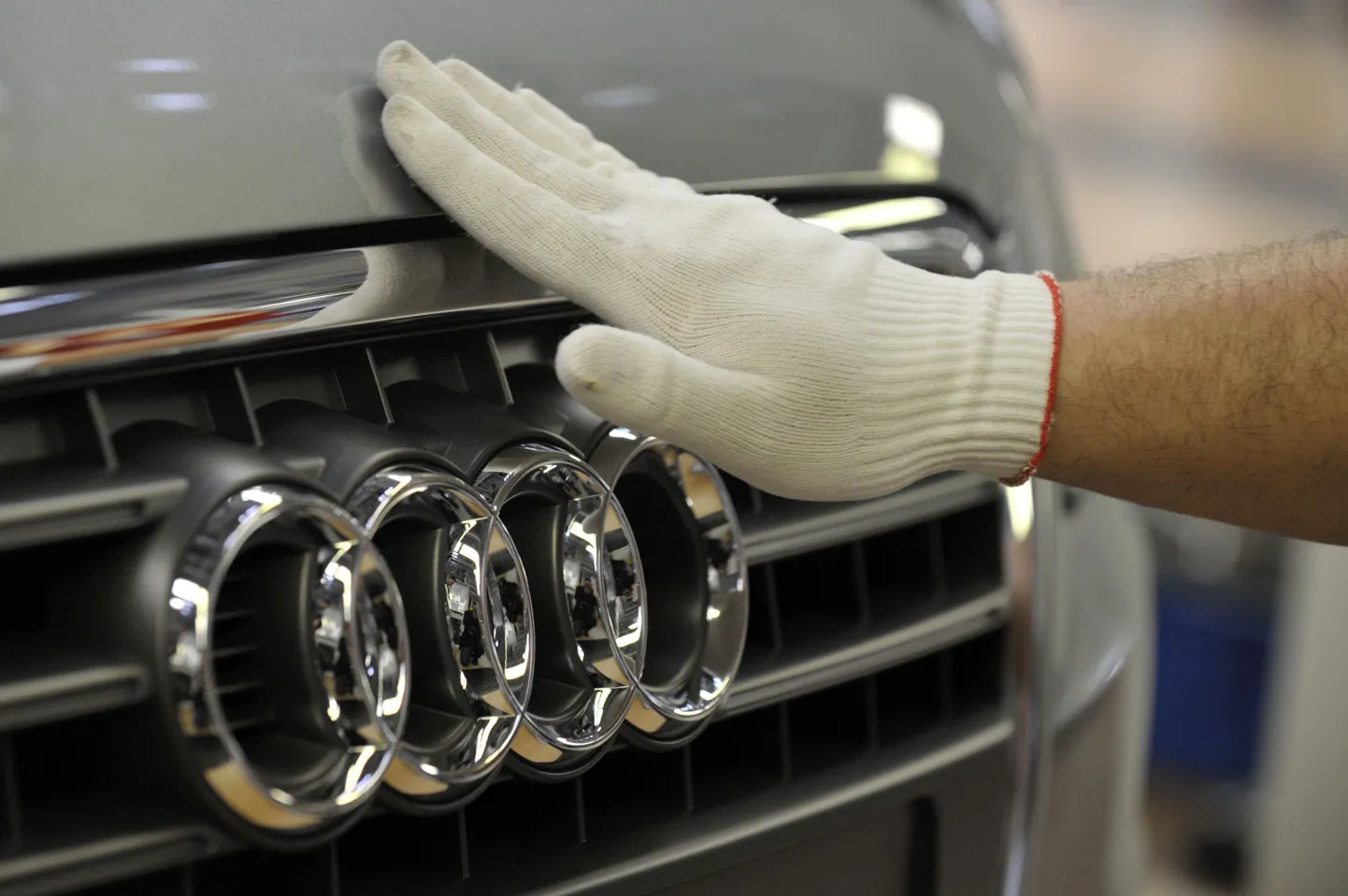 Audi töötaja Neckarsulmi tehases uue A4 koonu silitamas.