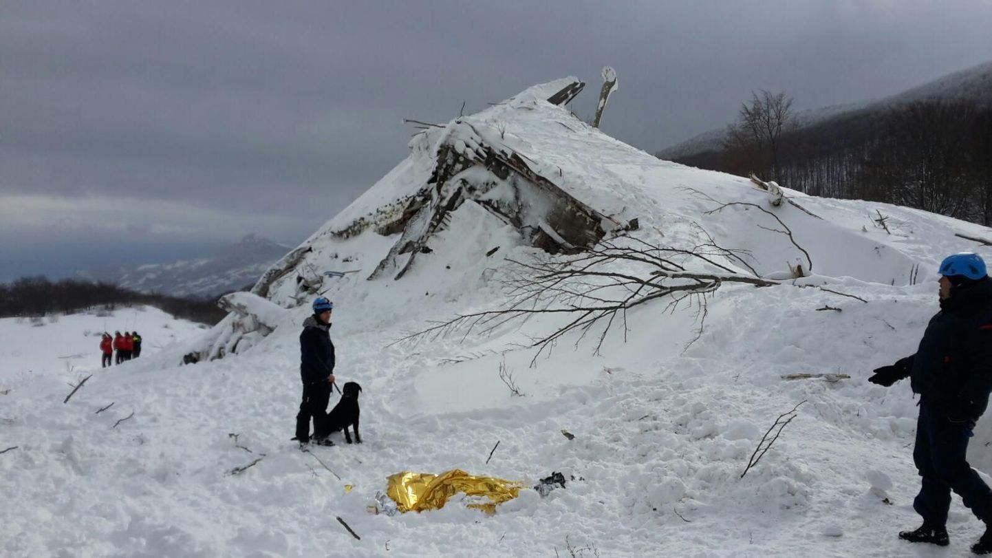 Päästetöötajad Itaalias lume alla mattunud hotelli juures.