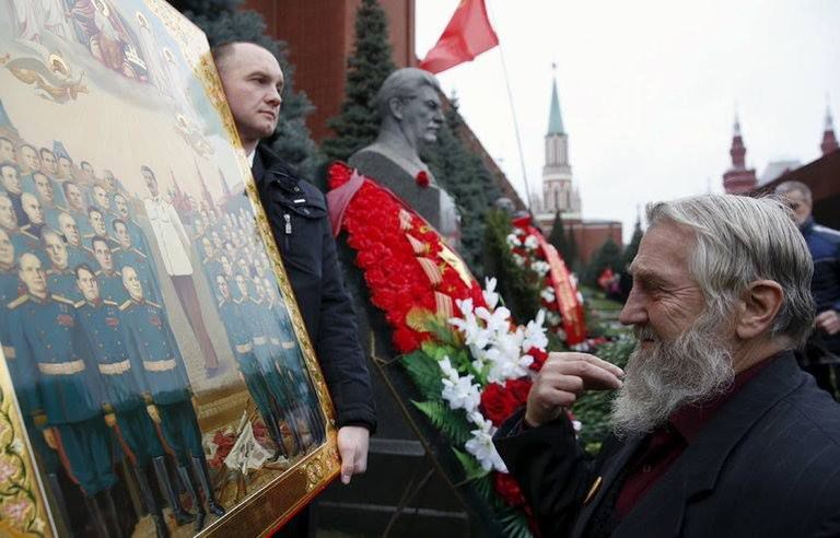 Vene mees lööb risti ette Nõukogude Liidu endise juhi Jossif Stalini – mehe, kes on vastutav miljonite inimeste tapmiste eest – ikooni ees / Scanpix