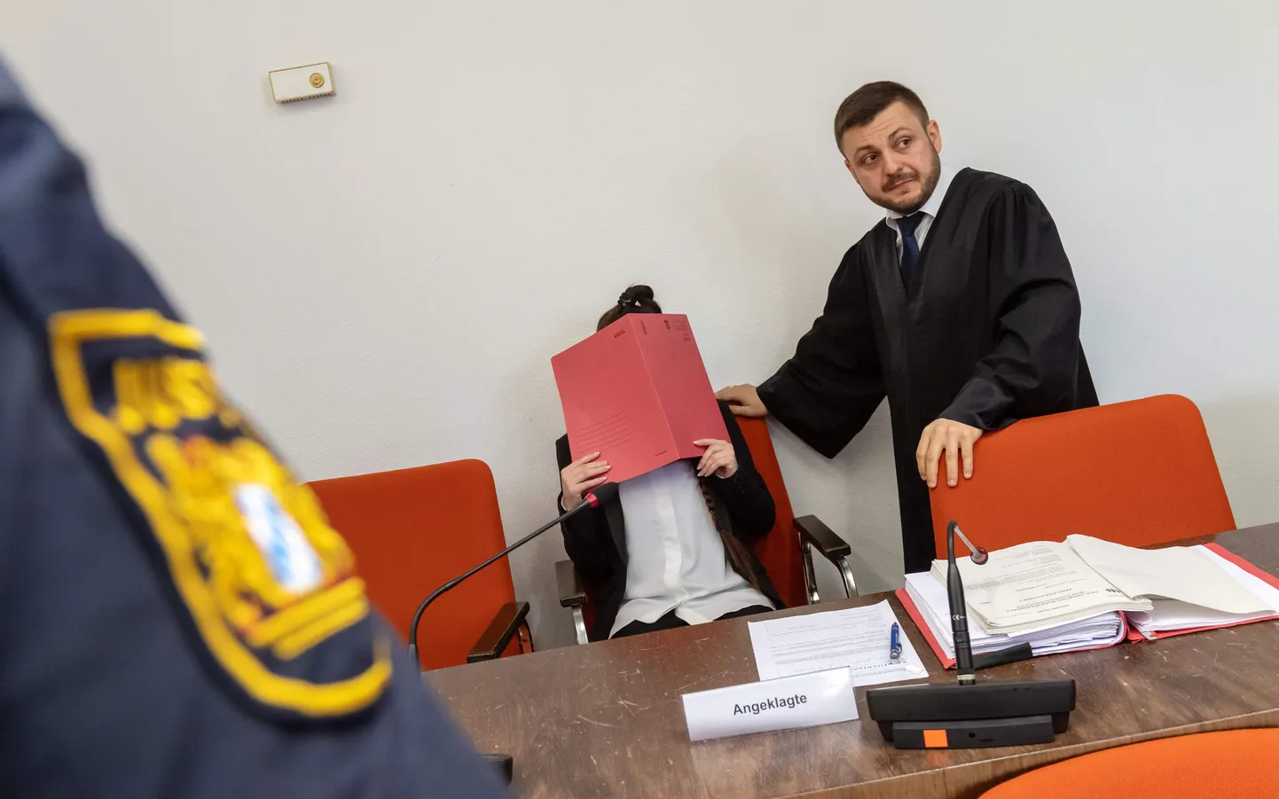 Jennifer Wenisch advokaadi kõrval istudes oma nägu varjamas.