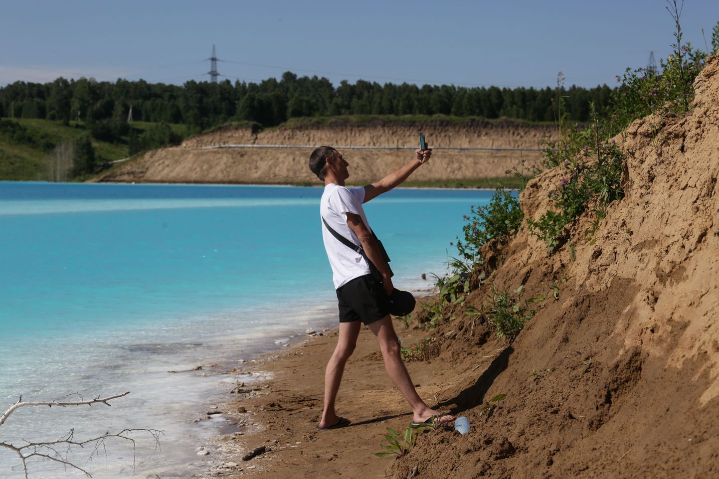 Mees mürgise järve kaldal selfit tegemas.
