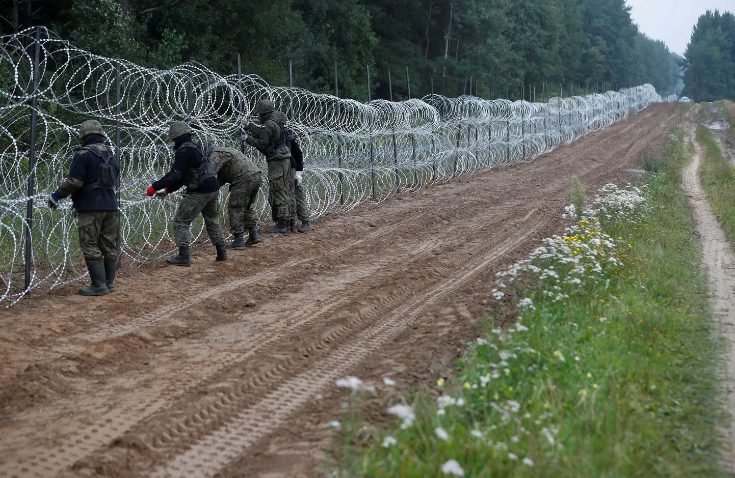 Poola sõdurid ehitamas traattõket Poola-Valgevene piirile.