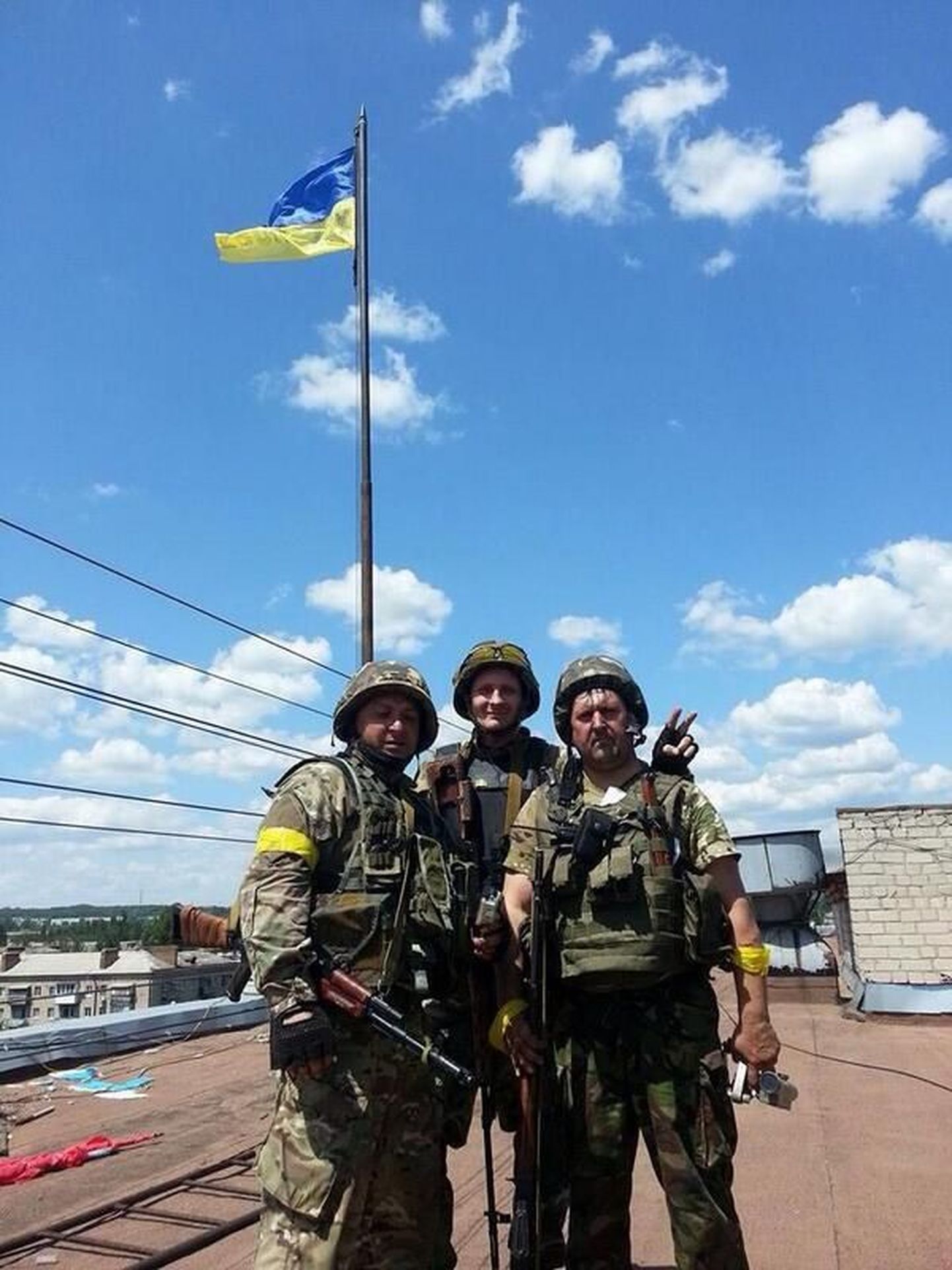 Ukraina valitsusvägede sõdurid täna Slovjanskis riigilipu taustal poseerimas.