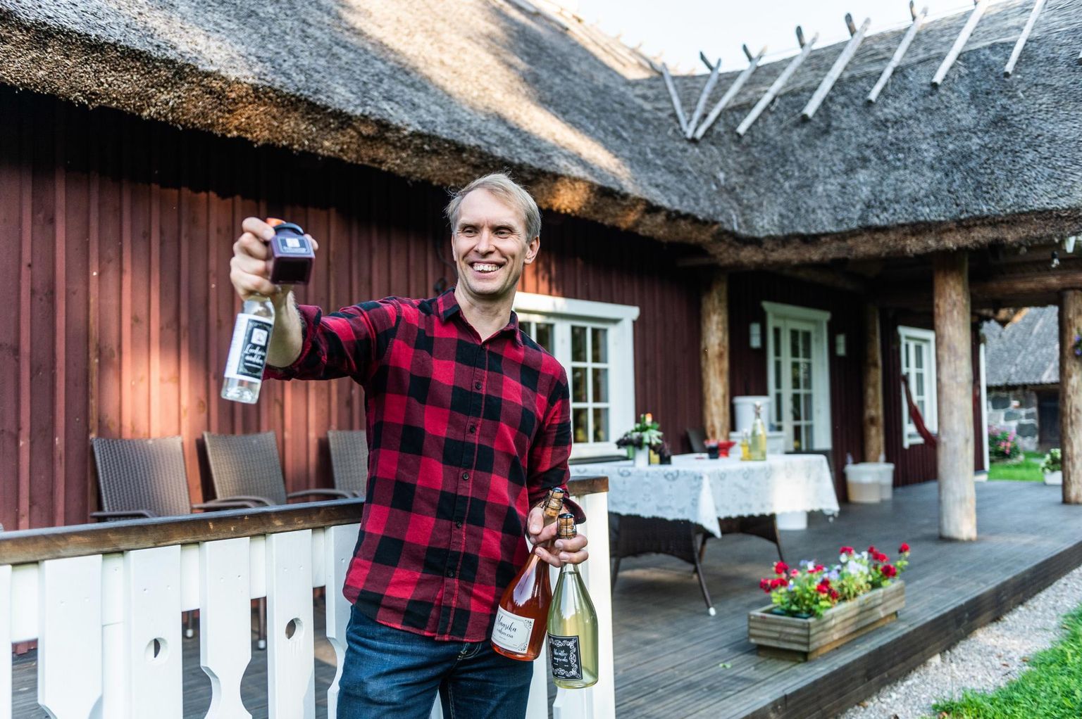 Tänava talu peremees Margus Maripuu hoiab käes oma taluköögis tehtud kihisevaid jooke, leedriõieäädikat ja põldmarjasinepit.