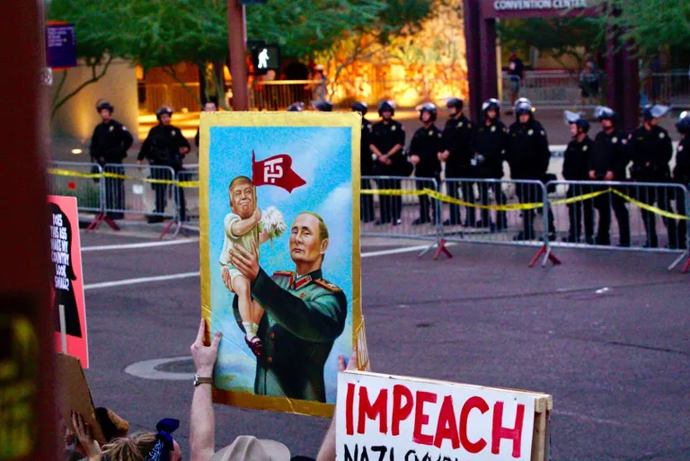 Donald Trumpi pilav plakat. Kõrval silt, millel nõutakse tema tagandamist. / Scanpix
