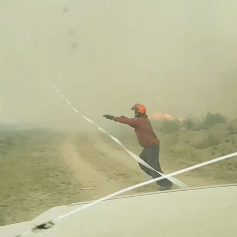 Tuletõrjuja üritab tuletornaadosse sattunud voolikut kätte saada