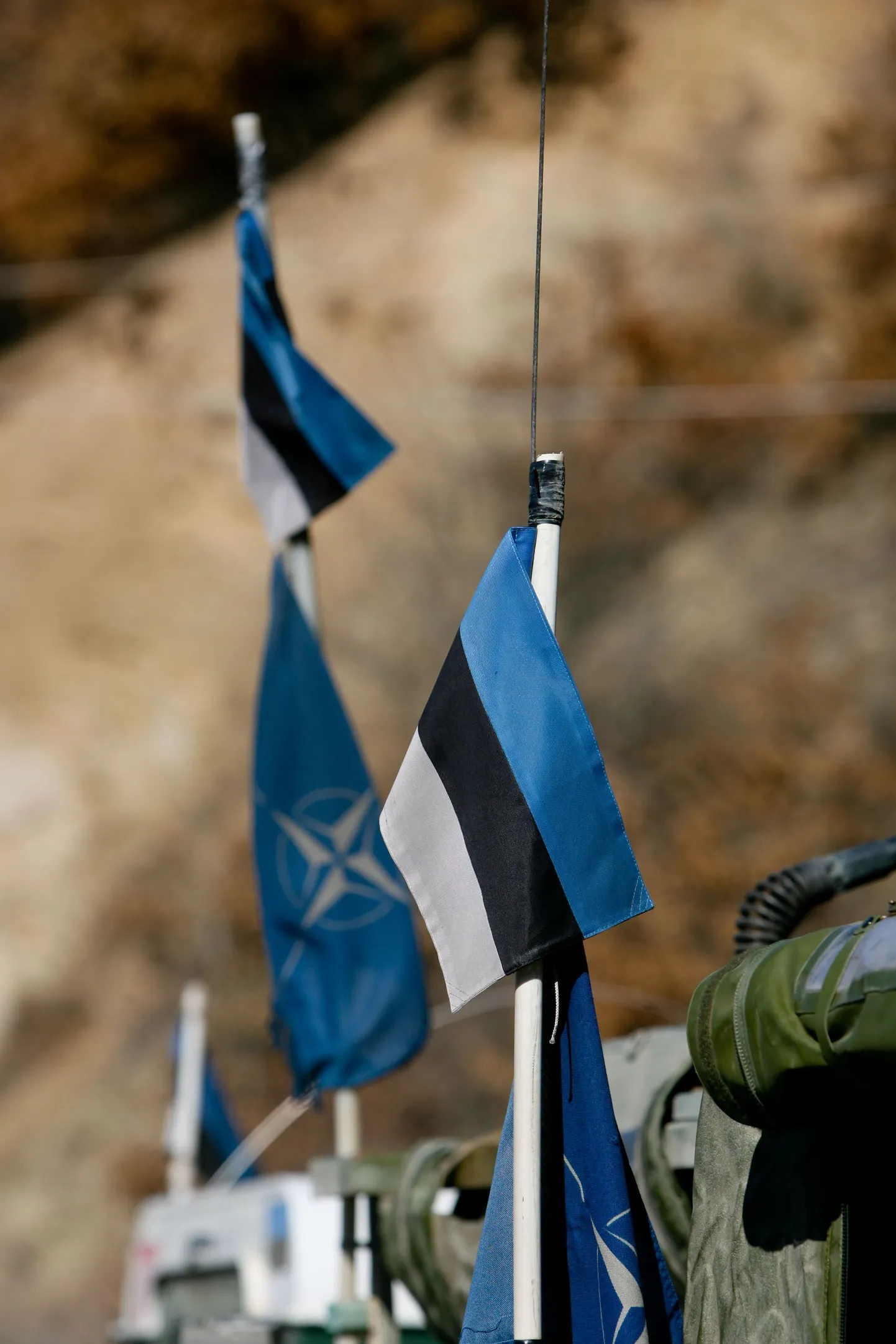 NATO ja Eesti lipud sõjaväe maasturi küljes.