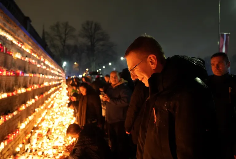 Valsts prezidents Edgars Rinkēvičs par godu Latvijas brīvības cīnītājiem noliek svecītes pie Rīgas pils mūra 11.novembra krastmalā.