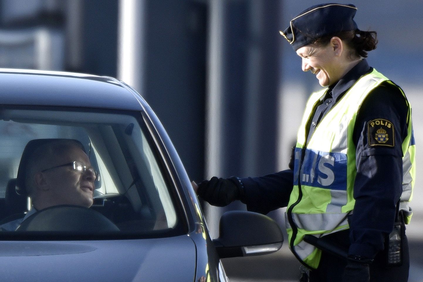 Rootsi politseinik kontrollimas piiriületaja dokumente Öresundi väina ääres.