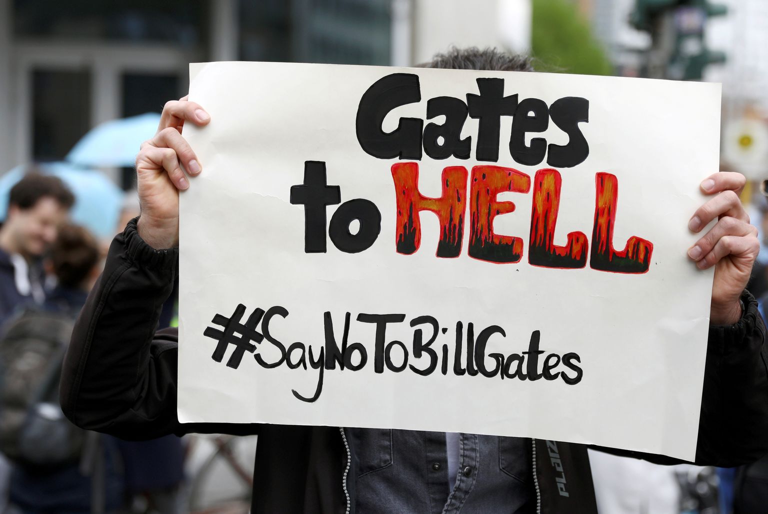 Meeleavaldaja hoidmas plakatit, millel on kiri: "Gates põrgusse. #ÜtleEiBillGatesile"