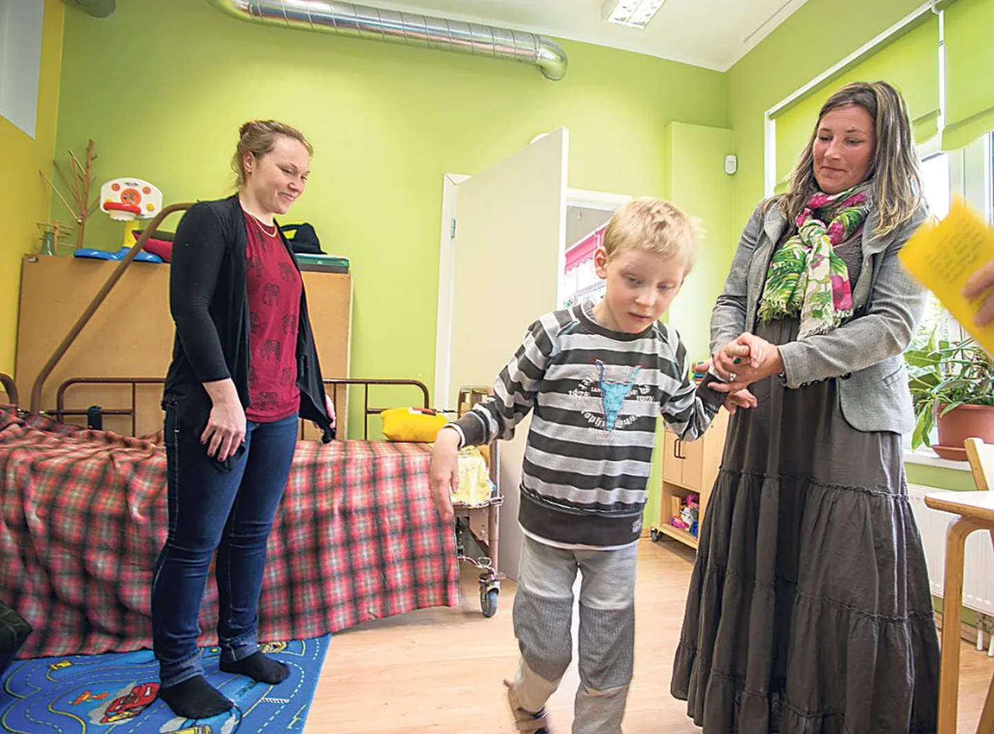 Seitsmeaastane Karel on esimest päeva hoiukodus kasvataja Lisanne Lergi (vasakul) hoole all. Teda toetab pildistamise hetkel MTÜ Eliise Puhkusepesa juhatuse liige Anu Pikk.