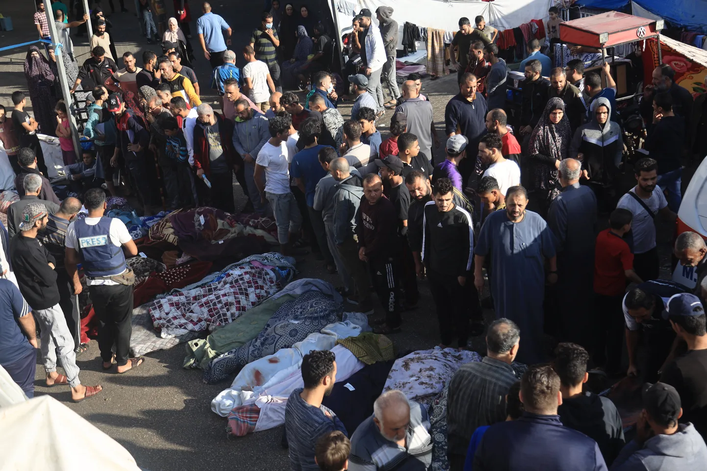 Inimesed Al-Shifa haigla kõrval surnukehade juures.