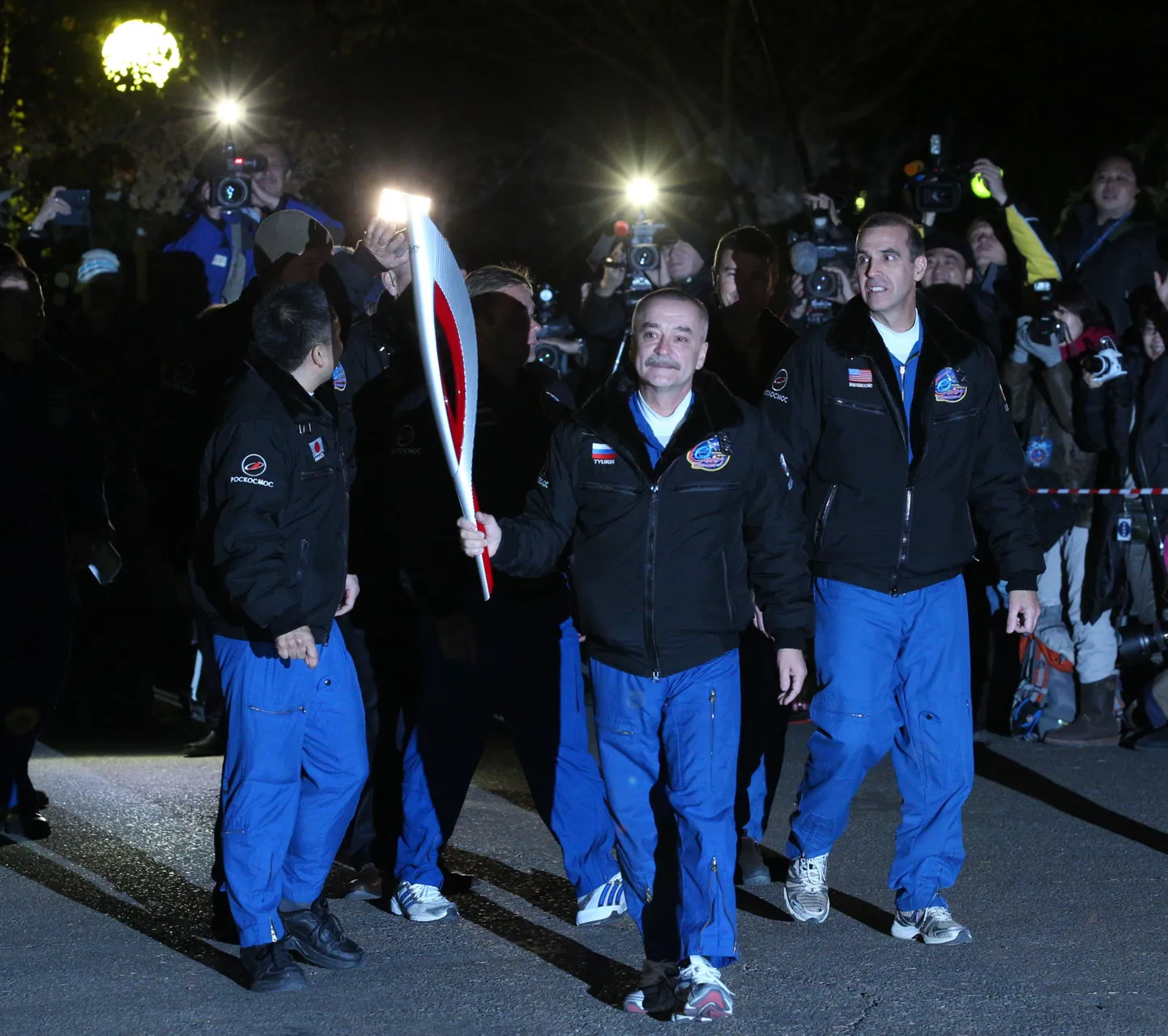 Космонавты с олимпийским факелом перед стартом.