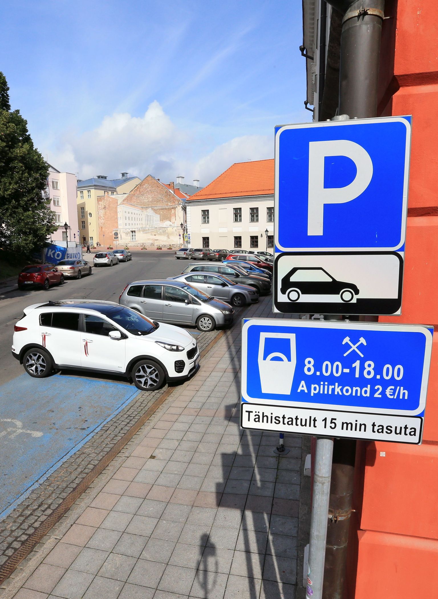 Raekoja taga selgitab lisatahvel, et auto tuleb parkida kõnnitee suhtes risti. Kuid linn on märki paigaldades tahtnud tähelepanu juhtida ka sellele, et auto summuti ei oleks suunatud raekoja poole.