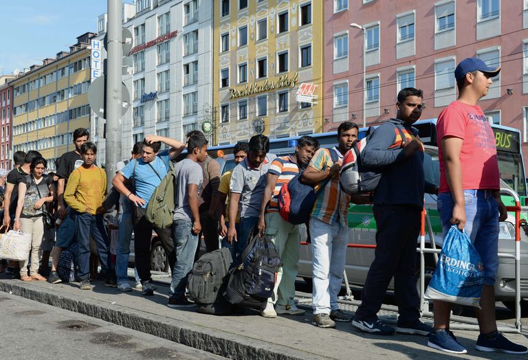 Migrants line up to catch a bus after their arrival at the main train station in Munich, southern Germany, September 1, 2015. Hundreds of migrants arrived in Munich with train's from Hungary and Austria during the night and the morning of September 1, 2015. AFP PHOTO / CHRISTOF STACHE