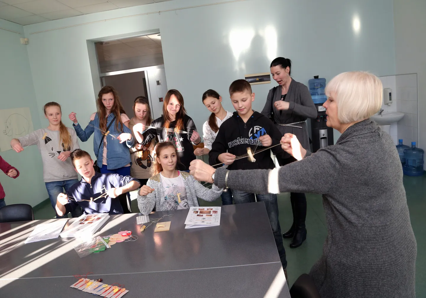 Eesti Rahva Muuseumi giid Virve Tuubel (paremal) on nagu dirigent ja Puškini kooli õpilased nagu vurrikoor, kes kõik vurrilaulust rõõmu tunnevad.