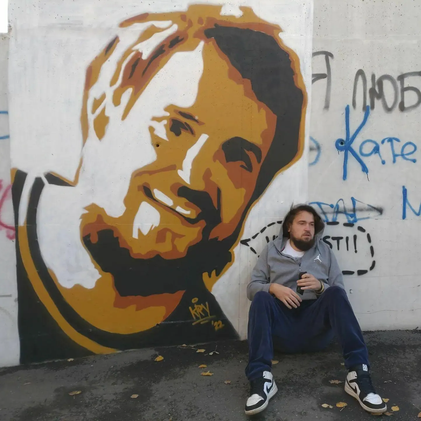 Sander Õigus enda näo järgi tehtud grafiti ees.