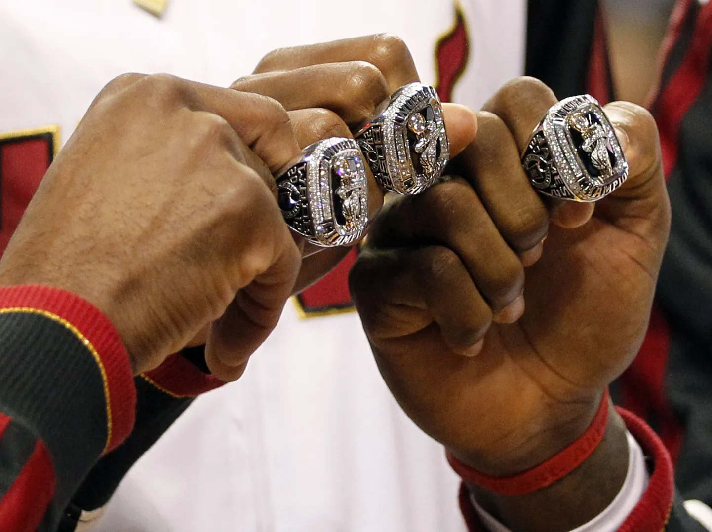 Dwyane Wade (vasakul), Chris Bosh (keskel) ja LeBron James NBA meistrisõrmuseid näitamas
