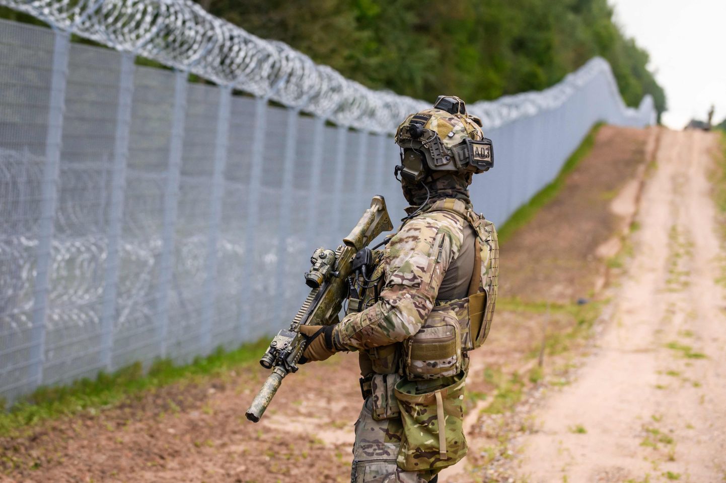 A member of the State Border Guard (SBG) patrols along the fence at the Latvia-Belarus border near Krivanda, Eastern Latvia on August 8, 2023.