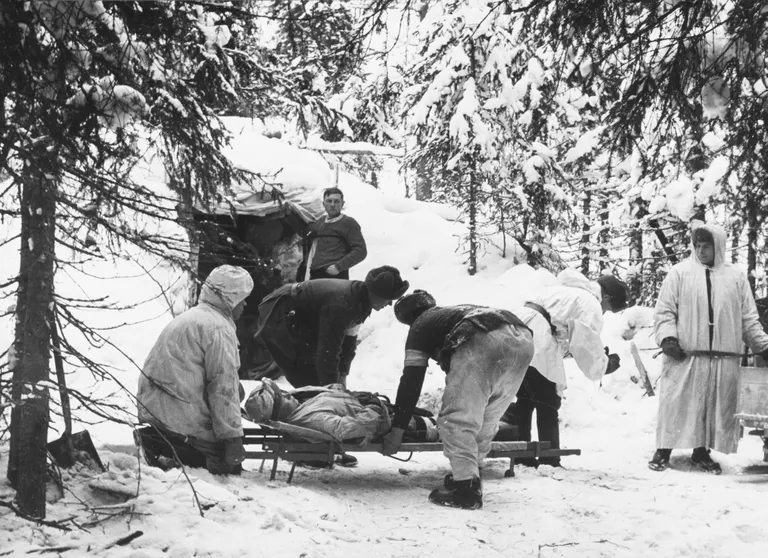 Soome sõdurid haavatud kaasvõitlejat kandmas.