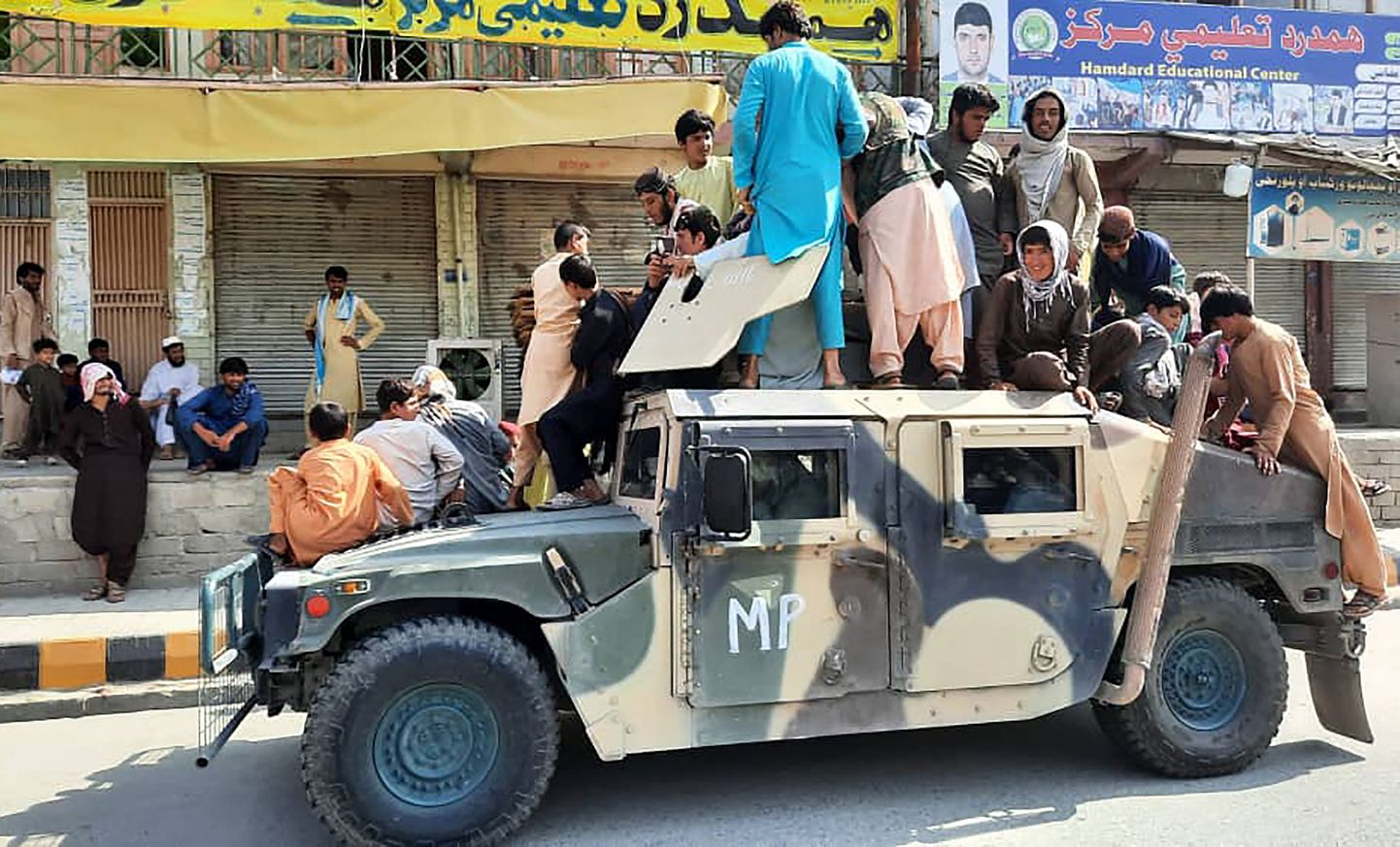 Taliban võitlejad koos kohalike elanikega valitsusvägede poolt hüljatud masinal Laghmani provintsis.